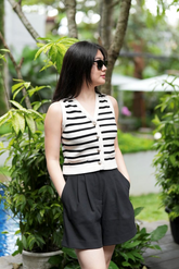 a lady in a striped cardigan and a pair of black shorts